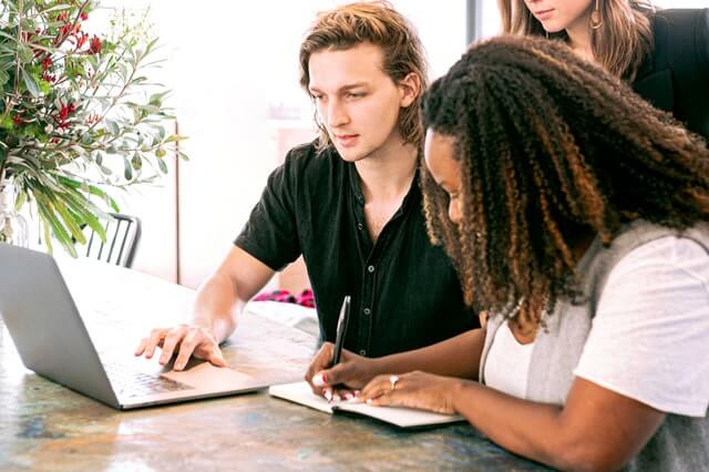 people writing and on laptop