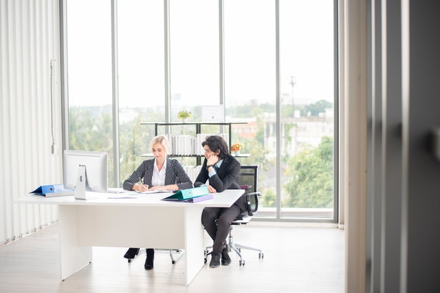 two people writing in office